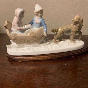 Meico boy and girl sledding, porcelain figurine on base